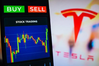 July 20, 2022, Brazil. In this photo illustration the stock market graphic seen on a smartphone with the Tesla, Inc. logo in the background