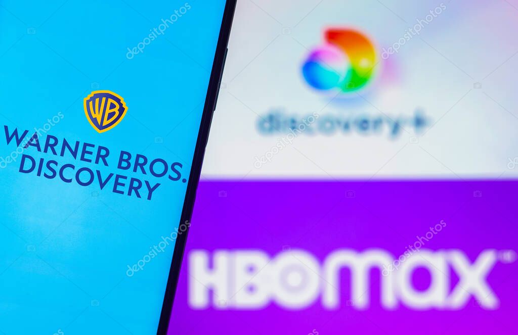August 5, 2022, Brazil. In this photo illustration, the Warner Bros. Discovery logo is displayed on a smartphone screen and in the background, the HBO Max and Discovery Plus logos