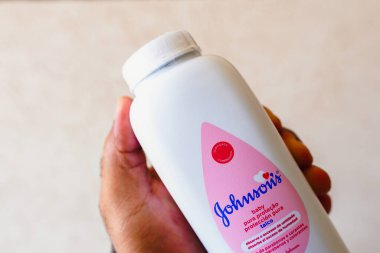 August 22, 2022, Brazil. In this photo illustration, a person holds a packet of Johnson & Johnson baby powder. The company will suspend the sale of the product from 2023