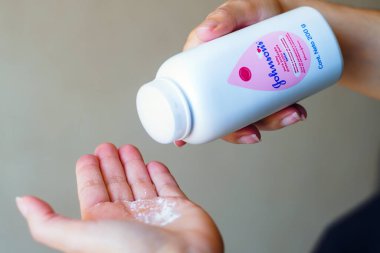 August 22, 2022, Brazil. In this photo illustration, a person uses Johnson & Johnson baby powder on their hands. The company will suspend the sale of the product from 2023