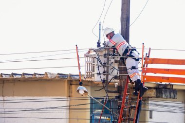 August 23, 2022, Brazil. In this photo illustration, Energisa electrician climbs a pole to fix power wires in Mato Grosso do Sul