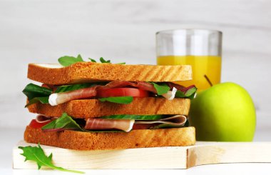 İspanyol jambonlu kulüp sandviçi veya İtalyan jambonu, meyve suyu ve elma suyu.