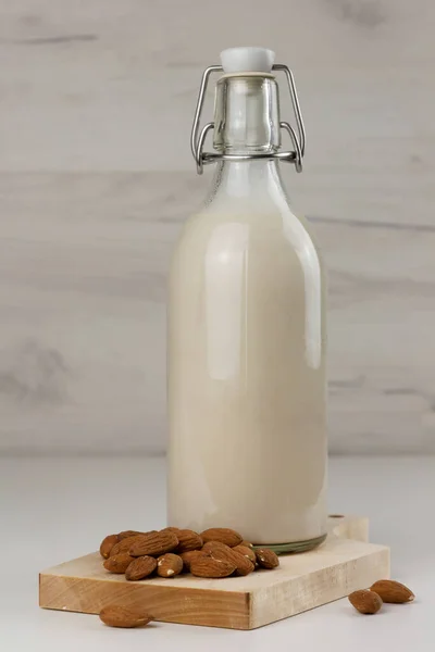 奶瓶中的免费杏仁牛奶和浅色背景的坚果 — 图库照片