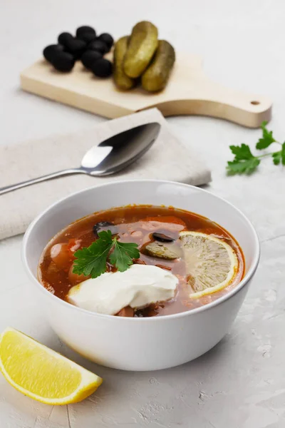 Sopa tradicional de carne rusa Solyanka en un tazón blanco e ingredientes —  Fotos de Stock