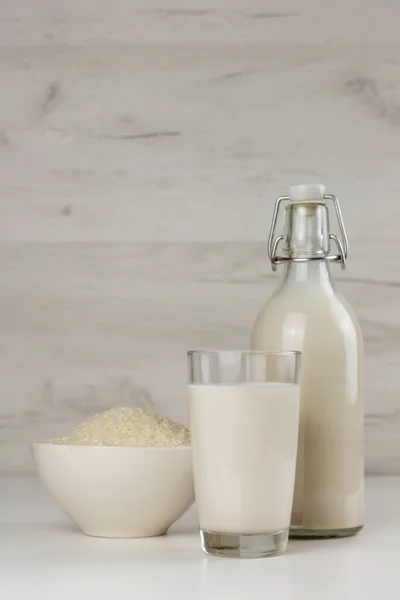 一个瓶子和一个杯子 里面装着免费的米奶和种子 乳糖免费饮料 — 图库照片