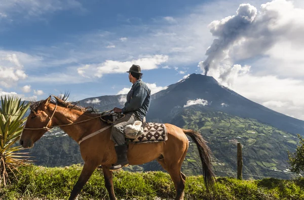 Agricultor em um cavalo olhando para a erupção do vulcão Tungurahua — Fotografia de Stock