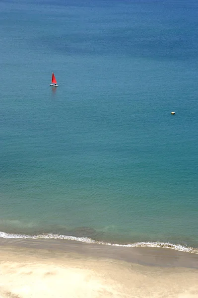 Fondo Con Una Pequeña Vela Roja Medio Enorme Mar Azul —  Fotos de Stock