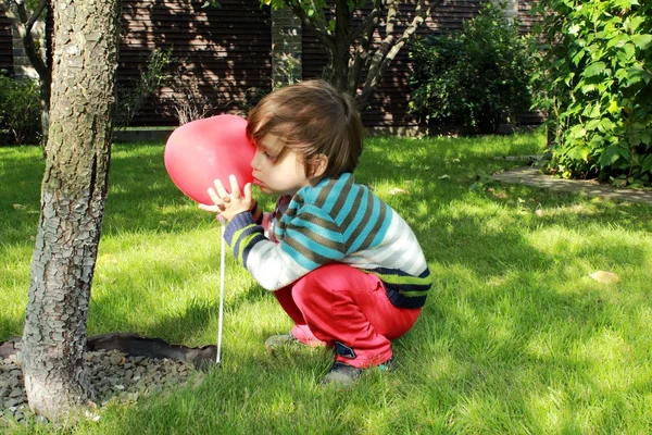 Little one with red heart balloon — Stock Photo, Image