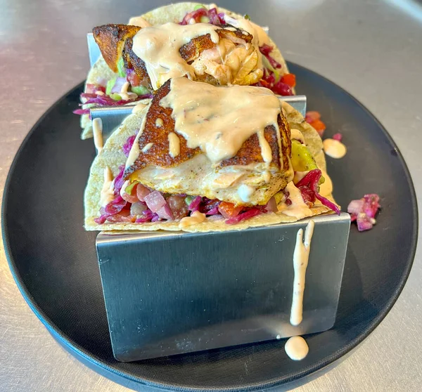 Taco tepsisinde salsa soslu somon tacoları.