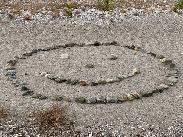 Plaj resimleri; kumsaldaki kayalardan yapılmış gülen bir yüz.