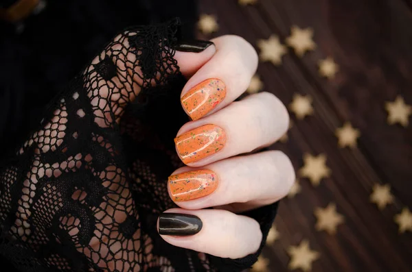 Female Hand Orange Glitter Nails Holds Orange Nail Polish Dark — Stock Photo, Image