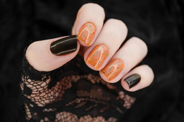 Kobieca Ręka Pomarańczowymi Brokatowymi Paznokciami Trzyma Pomarańczowy Lakier Paznokci Ciemnym — Zdjęcie stockowe