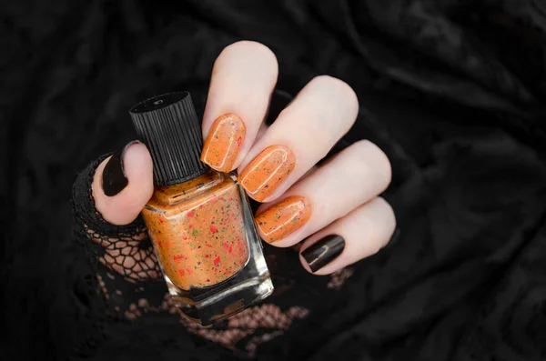 Weibliche Hand Mit Orangefarbenen Glitzernägeln Hält Orangefarbenen Nagellack Auf Dem — Stockfoto