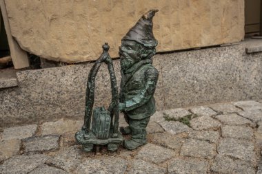 Wroclaw, Polonya - 20 Ağustos 2019: Porter cücesi otel bavulları (Bagazowy) - 2005 yılından beri şehirde yüzlerce wroclaw cüce figürü belirdi - Wroclaw, Polonya