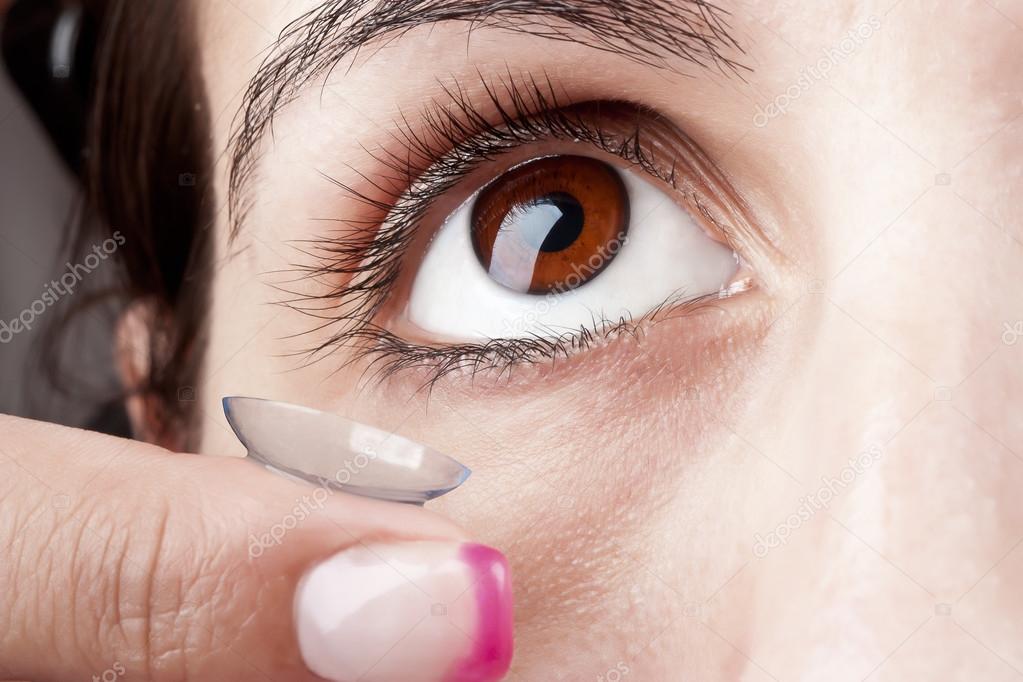 Woman puts on a Contact Lens