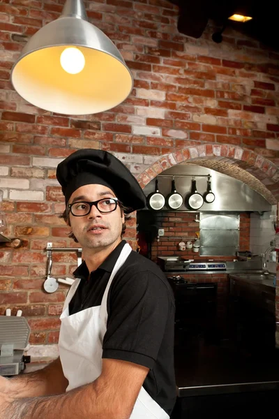 Pizzabäcker steht in der Küche und arbeitet — Stockfoto