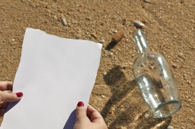 Woman reading a message that came in a bottle (Write your own text) clipart