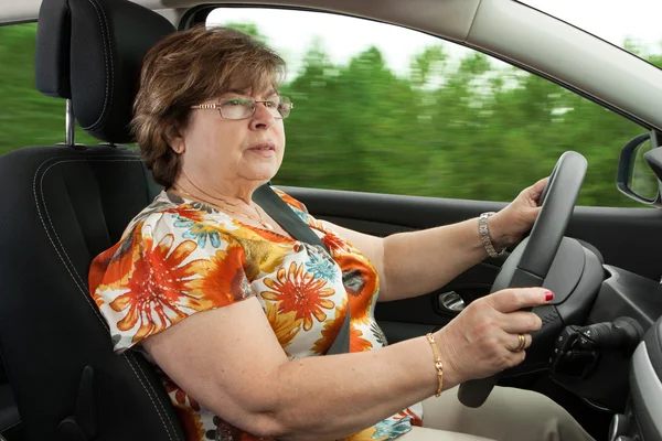 Senior kvinna som kör bil Stockbild