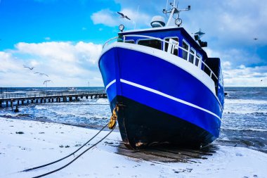 2021, 25 Aralık, Polonya, Ustronie Morskie - Kıyıdaki mavi balıkçı teknesi