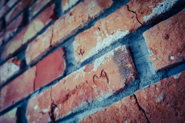 Eski, kırık tuğlalar ve duvarda harfler.