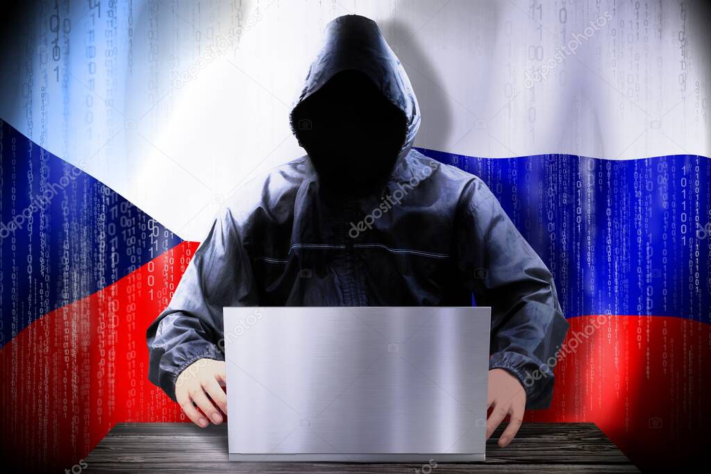 Anonymous hacker working on a laptop, flags of Czech Republic and Russia