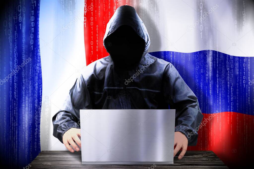 Anonymous hacker working on a laptop, flags of France and Russia