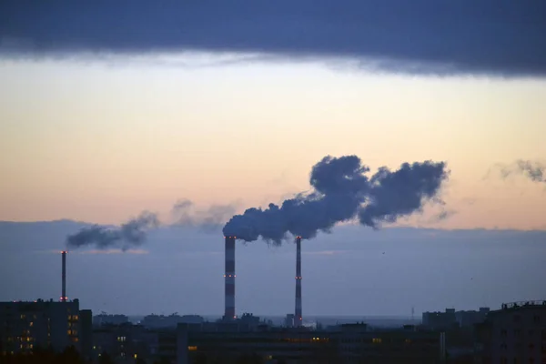日没時に工場の煙突から煙が出る — ストック写真