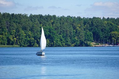 Sailboat swimming on a lake - front view