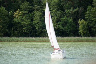 Sailboat swimming on a lake - front view