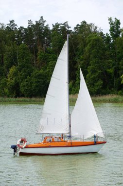 Göl kenarında yüzen yelkenli.