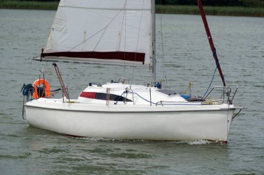 Sailboat swimming on a lake - side view