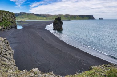 Reynisfjara - black beach in Iceland, single rock and cliffs