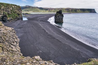 Reynisfjara - black beach in Iceland, single rock and cliffs