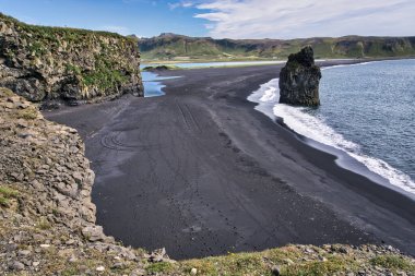 Reynisfjara - black beach in Iceland, single rock and cliffs