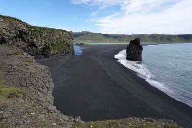 Reynisfjara - black beach in Iceland, single rock and cliffs