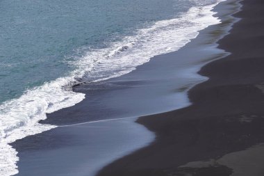 Reynisfjara - black beach in Iceland, close-up on waves