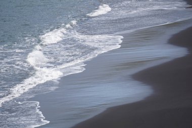 Reynisfjara - black beach in Iceland, close-up on waves
