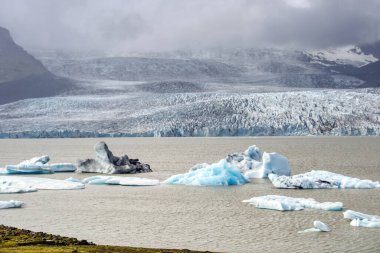 Fjallsarlon Iceberg Lagoon in Iceland - glacier, ice floes, mountains and lake shore