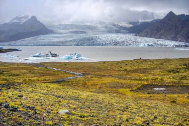 Fjallsarlon Iceberg Lagoon in Iceland - glacier, ice floes, mountains and lake shore
