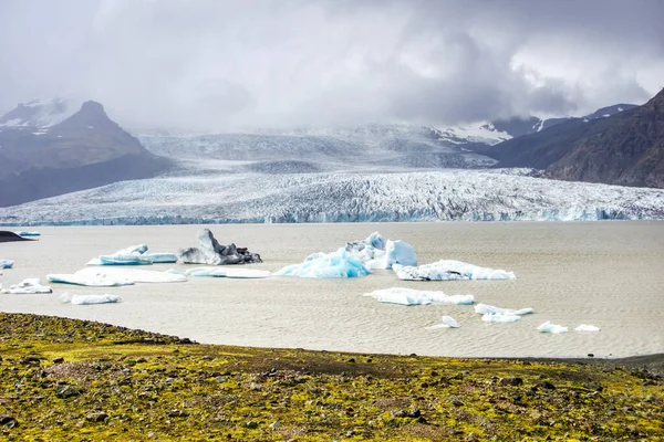 Fjallsarlon Iceberg Lagoon in Iceland - glacier, ice floes, mountains and lake shore