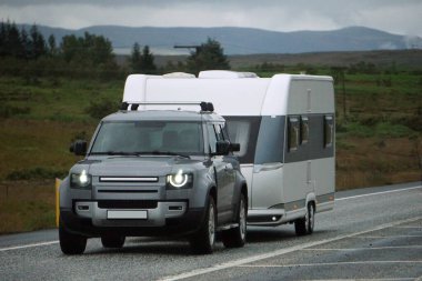 Iceland, Sudurland - August 8th, 2022 - Car towing a trailer on a road.