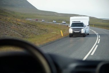 Iceland, Sudurland - August 8th, 2022 - Car towing a trailer on a road.