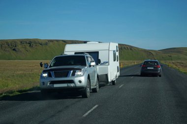 Iceland, Sudurland - August 8th, 2022 - Car towing a trailer on a road.