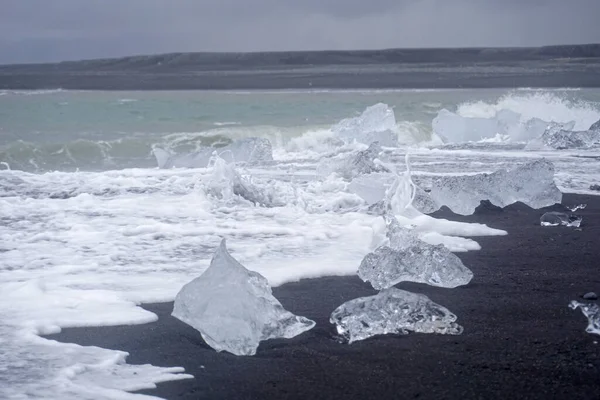 Blocks of ice laying on black volcanic sand - Diamond Beach, Jokulsarlon, Iceland