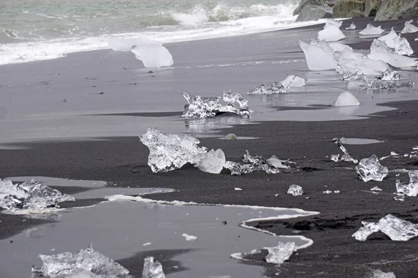 Blocks of ice laying on black volcanic sand - Diamond Beach, Jokulsarlon, Iceland