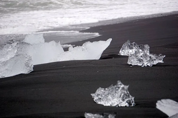 Blocks of ice laying on black volcanic sand - Diamond Beach, Jokulsarlon, Iceland