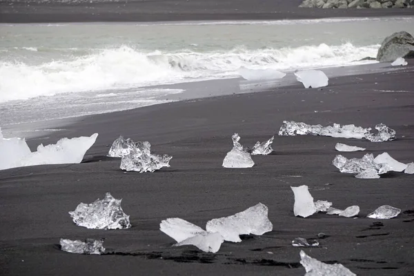 Blocks of ice laying on black volcanic sand - Diamond Beach, Jokulsarlon, Iceland