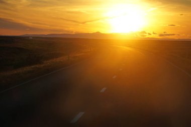 Driving a car in Iceland, sunset sky