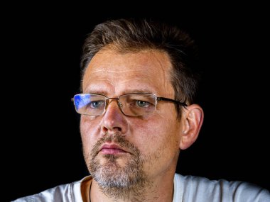 Görüş için gözlüklü sakallı bir adamın portresi. Gri sakallı bir adam. Portre. Görüş için gözlük. Bir yetişkinin yüzü. Halkın çağı. Siyah arka plan. Babalar Günü.