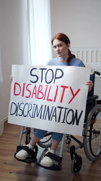 Una mujer atractiva discapacitada está mostrando un cartel y mirando a la cámara — Foto de Stock